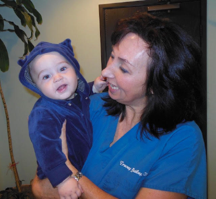 Dr. Tracey holding baby in blue